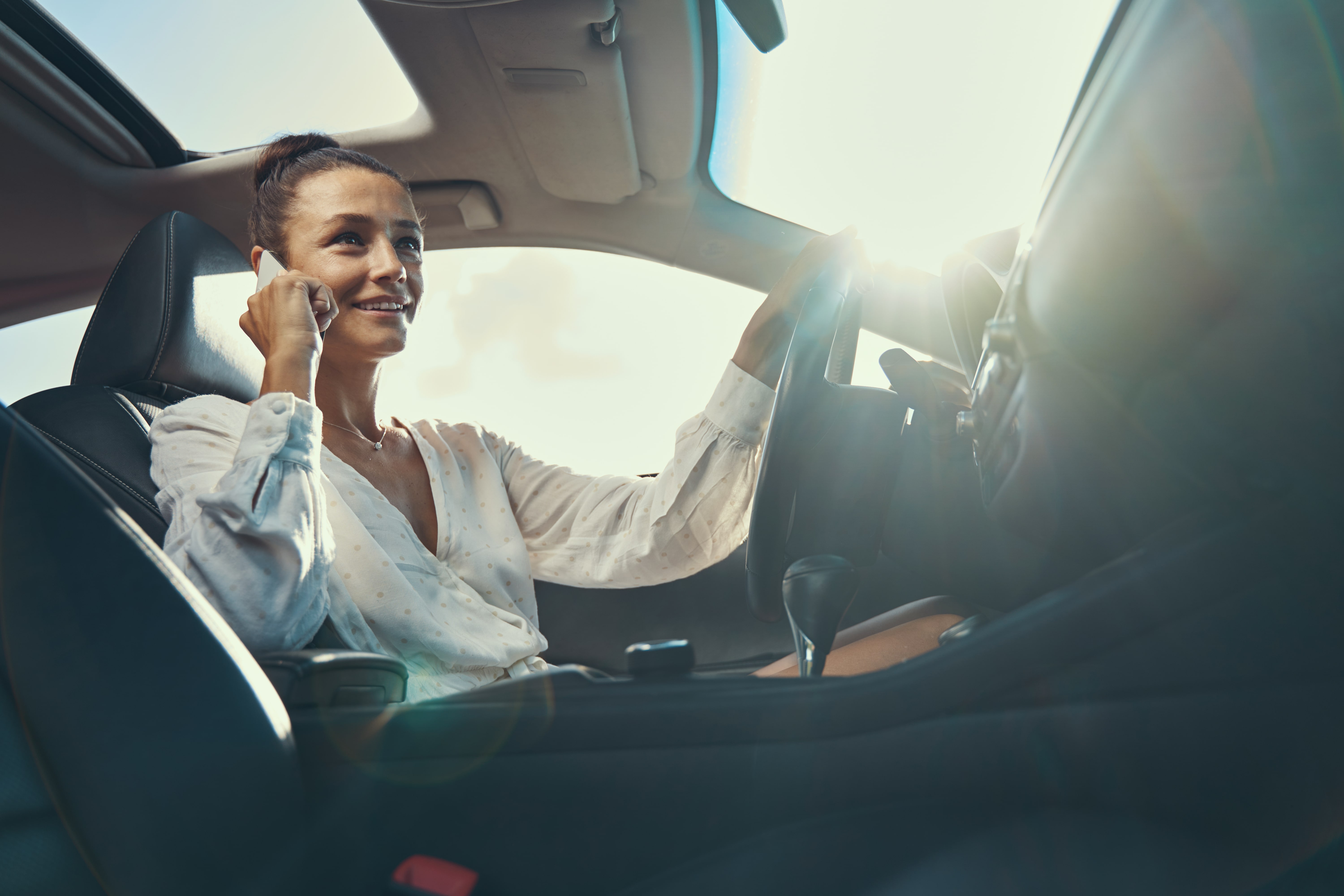 woman-driving-a-car-while-speaking-through-mobile--LB2JVNG-min